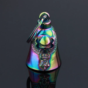 Macro shot of rainbow stainless steel motorcycle bell with winged skull relief detail