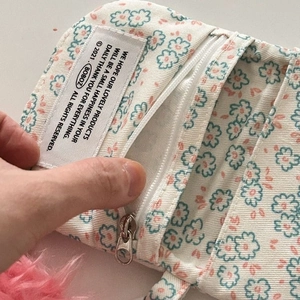 Close-up of floral canvas coin purse zipper detail and internal compartment structure