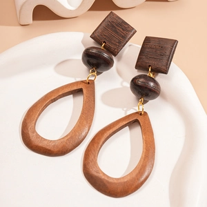 Detail view of vintage wooden geometric earrings with square and teardrop shapes on a tray