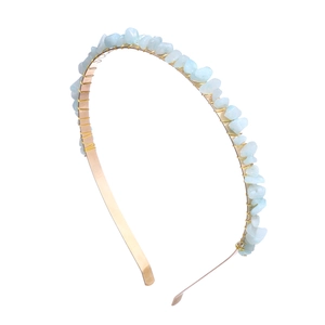 Macro detail of natural light blue crushed stone wrapped on a gold metal headband