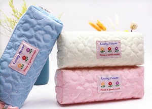 Detailed view of quilted floral stationery pouches in blue, white, and pink fabric