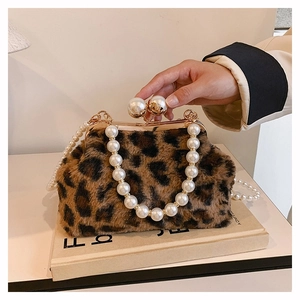 Detail of leopard print plush handbag featuring elegant pearl handle and gold metal clasp