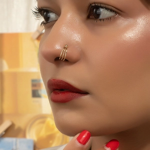 Close-up of a three-layer gold non-pierced nose ring on a model for a stylish look