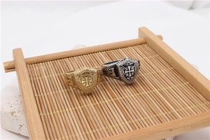 Macro view of vintage gold and silver knight shield rings with cross engraving