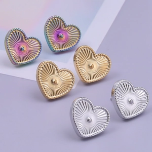 Detailed macro view of heart-shaped stainless steel earrings in gold, silver and rainbow finish