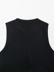 Macro view showing the soft texture and matte finish of black suede fabric on a V-neck vest