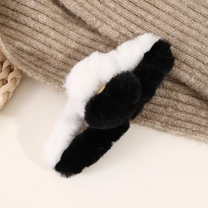 Close-up of black and white plush claw clip showing soft texture and metal spring