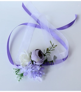 Detail of a purple silk wrist corsage with white rose and organza ribbon for weddings