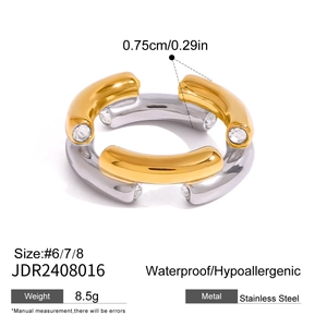 Detail view of two-tone stainless steel ring with four sparkling cubic zirconia stones