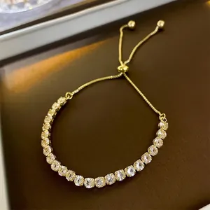Adjustable gold geometric tennis bracelet with square-cut cubic zirconia in a jewelry tray