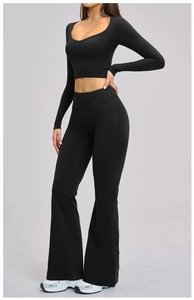Detail of high-waist flared yoga pants and crop top set in matte black stretch fabric