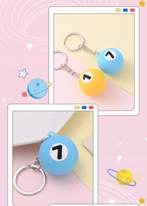 Close-up of number 7 billiard ball keychains in light blue and bright yellow colors