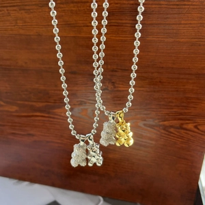 Close-up of bear pendants with micro-set zircon and polished finish on bead chains