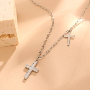 Detail of silver stainless steel O-chain necklace with white shell inlay cross pendant
