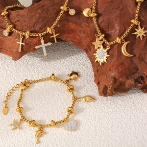 18k gold plated stainless steel bracelets with cross and ocean charms on wood background