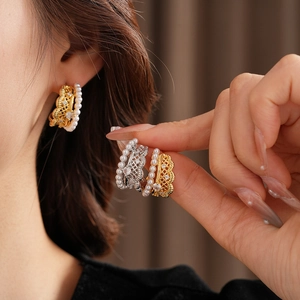 Detail of silver needle pearl earrings with lace metal mesh and zircon inlay
