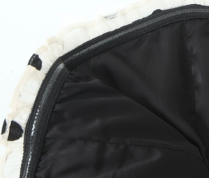Détail de la robe en velours noir avec fermeture anti-glisse et bordure à pois volantée