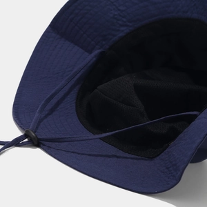 Detailed close-up of quick-dry navy bucket hat with mesh lining and adjustable wind cord