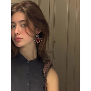 Gros plan sur des boucles d'oreilles fleur en or avec des pierres précieuses colorées