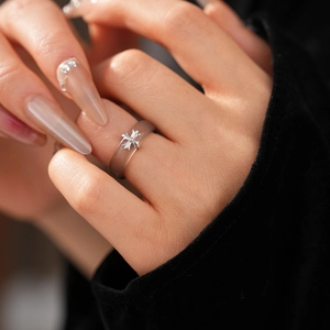 Macro detail of translucent resin cross ring featuring a vintage silver flower engraving