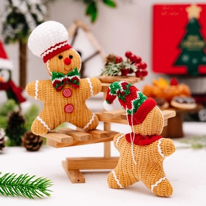 Close-up of knitted gingerbread man ornaments with festive chef and Santa hats