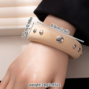 Close-up of beige leather bracelet with metal studs showing width and diameter details