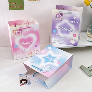 Elegant gradient paper gift bags in pink, purple and blue with woven handles and patterns
