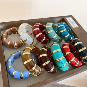 Detail of colorful acrylic resin segment bracelets with polished gold metal spacers