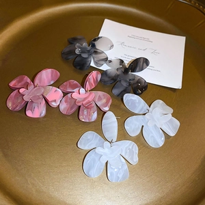 Minimalist acrylic flower earrings in marble black, pink and white on a gold tray
