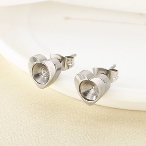 Macro detail of silver heart stud earring base with round setting for DIY jewelry design