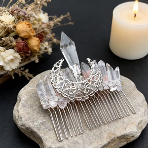 Detail of silver crescent moon hair comb with raw clear crystals on a natural stone base