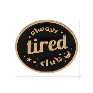 Detail showing dimensions of the black Always Tired Club enamel pin with gold trim