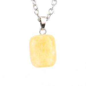 Detail view of a rectangular yellow raw crystal pendant on a silver metal chain