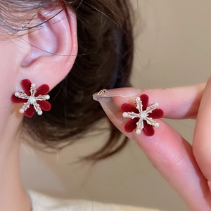 Close-up of red velvet flower earrings with zircon center and small white pearls