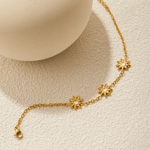Detailed macro view of 18K gold stainless steel chain with sun-shaped zircon charms