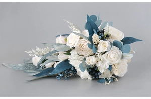 Detail of white roses and blue berries in a cascading teardrop bridal bouquet style