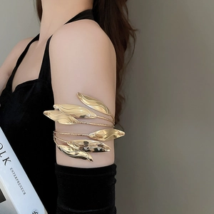 Detail of gold multi-layer leaf arm cuff with textured metallic foliage wrap