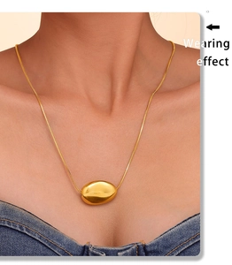 Wearing effect of a gold bean pendant on a sleek snake chain necklace for women