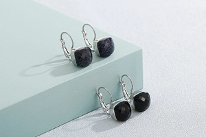 Macro view of square cut dark blue and black crystal stones on silver plated ear hooks