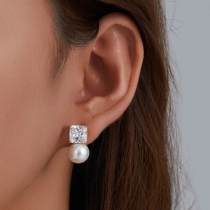 Elegant gold square cubic zirconia and pearl stud earrings for women on earlobe