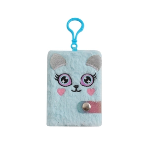 Dettaglio macro del taccuino unicorno di peluche con occhi ricamati e gancio in plastica