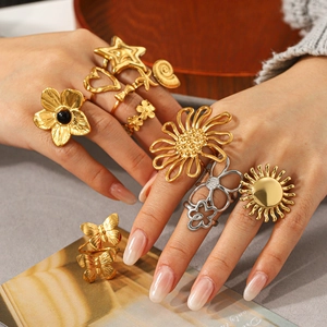 Detailed shot of stacked gold and silver rings featuring sun and floral motifs on fingers