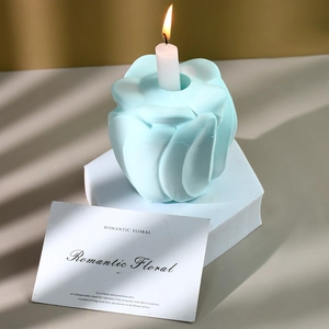 Detailed view of a light blue rose-shaped candle holder with a slim white candle