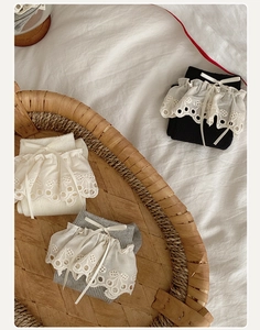 Detailed close-up of lace trim and satin bows on assorted vintage rib-knit cotton socks