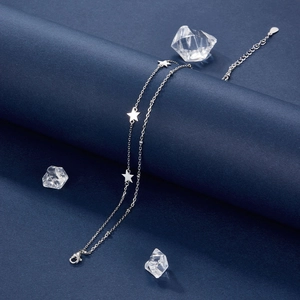 Elegant 925 sterling silver star anklet with adjustable chain on blue textured backdrop
