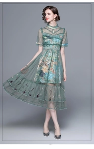 Detailed view of green floral embroidery and layered tulle ruffles on an elegant maxi dress