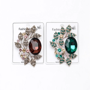Detailed view of vintage crystal leaf brooches in antique bronze and gold finish