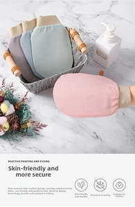 Nahaufnahme strukturierter Peeling-Handschuhe in Pastellfarben auf Marmor-Hintergrund