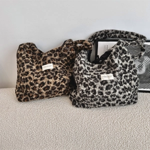 Detail of soft leopard print faux shearling tote bags with woven labels for autumn winter