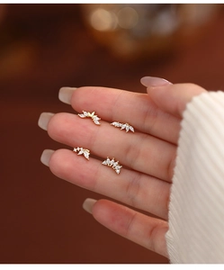 Detail of s925 silver leaf earrings with marquise cubic zirconia on fingers